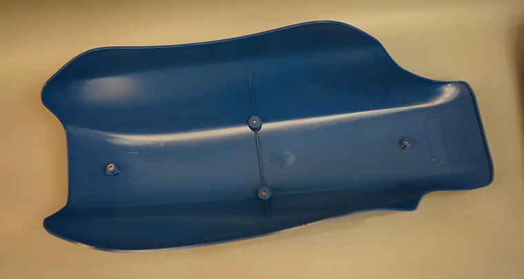 Seat housing with insert molding using embedded inserts for fastener assembly and secure component mounting.