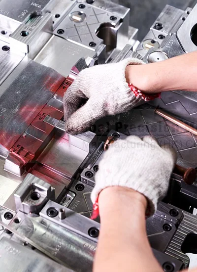 Technician inspecting and cleaning an injection mould to ensure proper maintenance and production quality